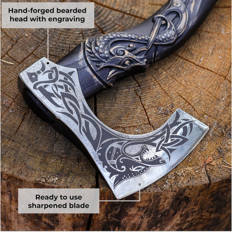Hand-forged axe with engraved design on a wooden surface