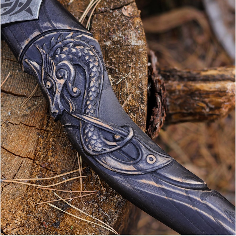 Decorative sword handle with intricate designs on a wooden surface