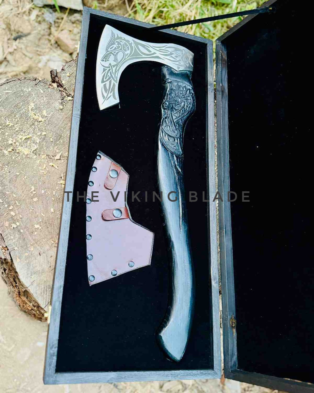 Decorative axe with intricate designs in a black case, branded 'The Vikingo Blade'.