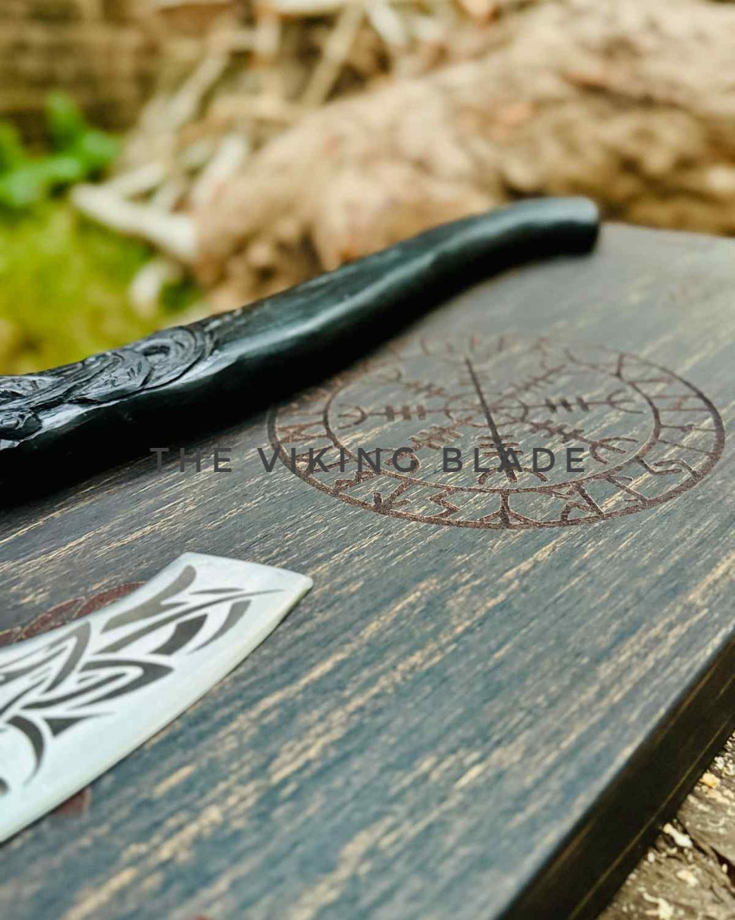 Decorative black blade with 'The Viking Blade' branding on a wooden surface.