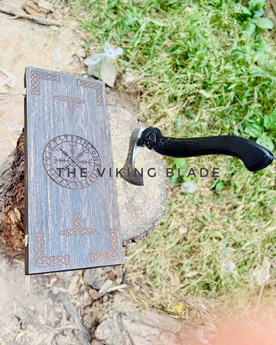 Viking-style axe with decorative sheath on a natural background