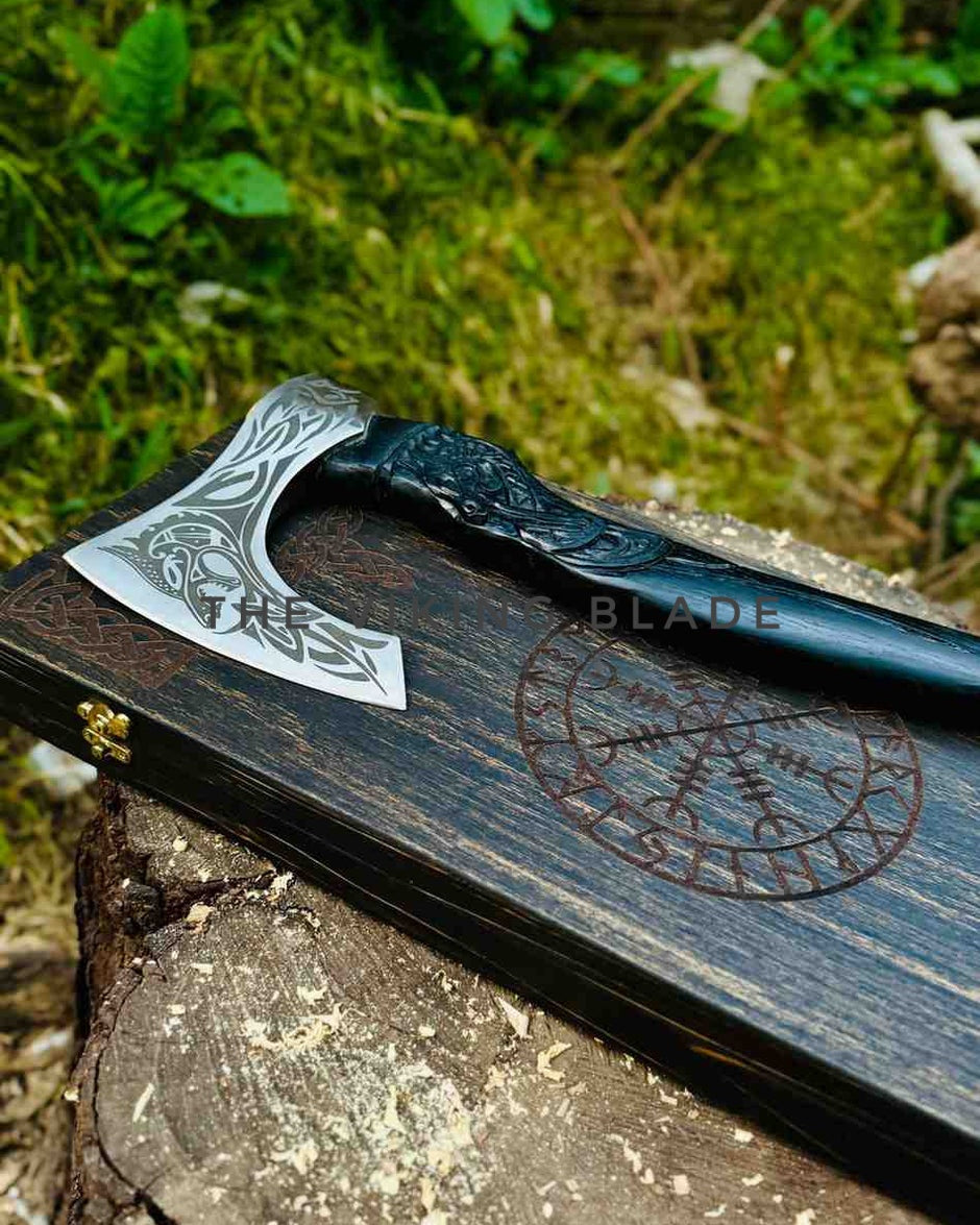 Decorative axe with engraved design on a wooden stand outdoors