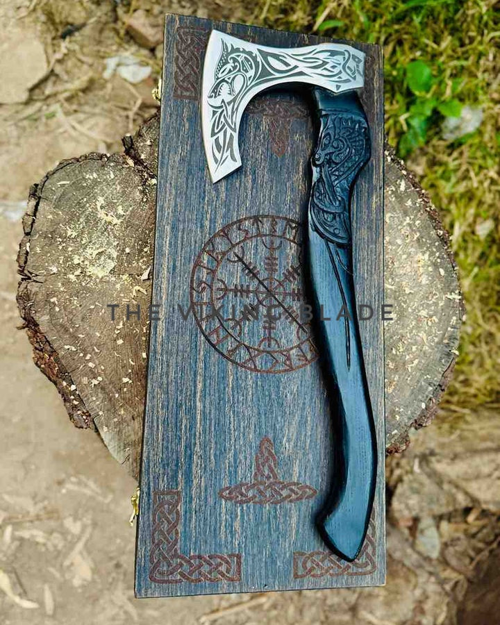 Decorative axe with a wooden sheath featuring Celtic designs on a natural background.