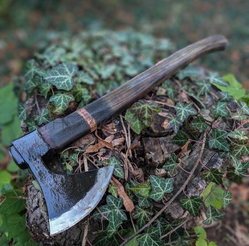 Axes on a log with green foliage in the background