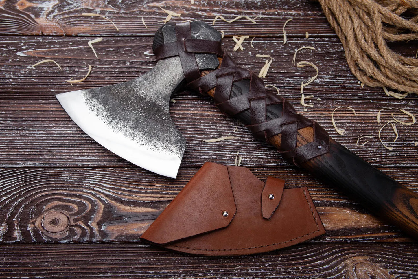 Axes with leather sheaths on a wooden surface