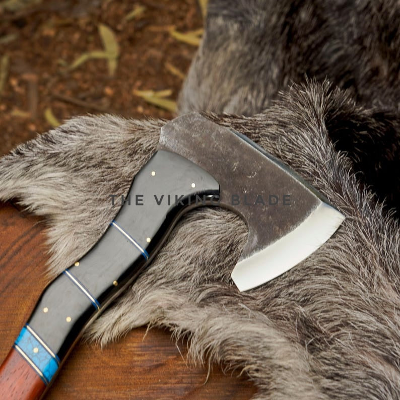 Viking-style axe on a fur surface with 'The Viking Blade' branding.