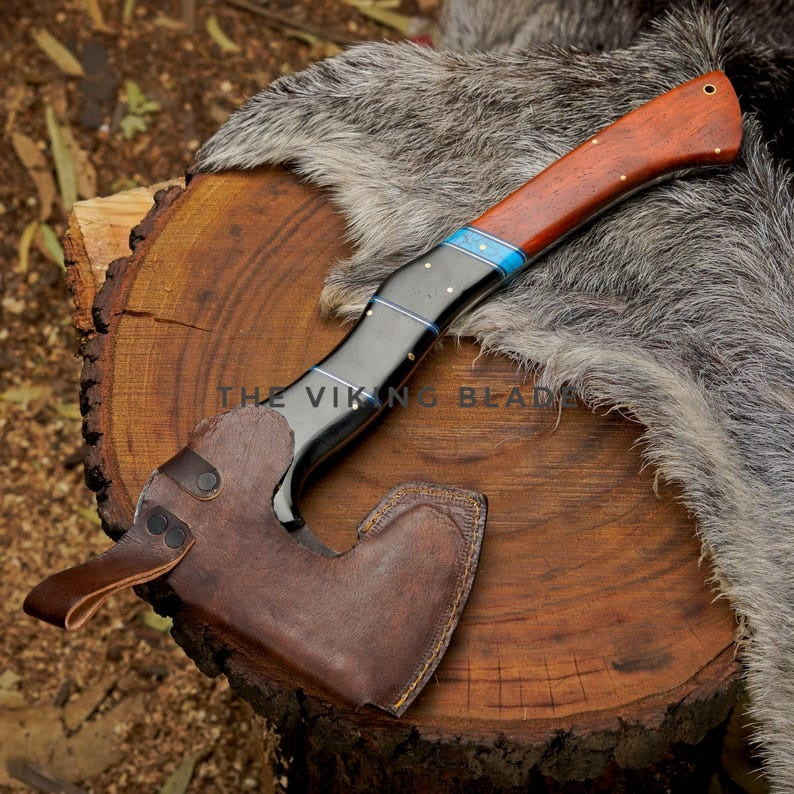 Viking-style knife with wooden handle and leather sheath on a wooden log