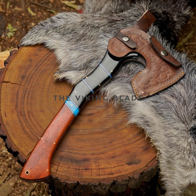 Wooden axe with leather handle on a wooden stump