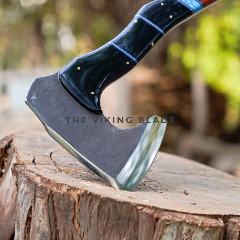 Axes with blue handles on a wooden block, branded 'The Viking Blade'.
