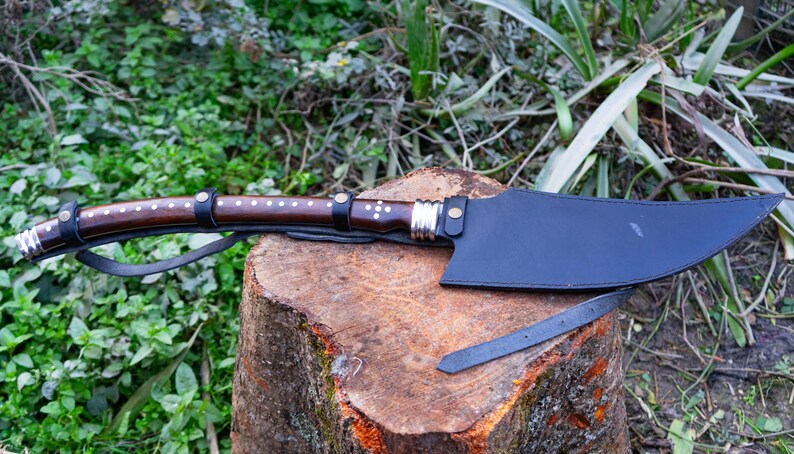 Knife with a wooden handle on a tree stump in a natural setting
