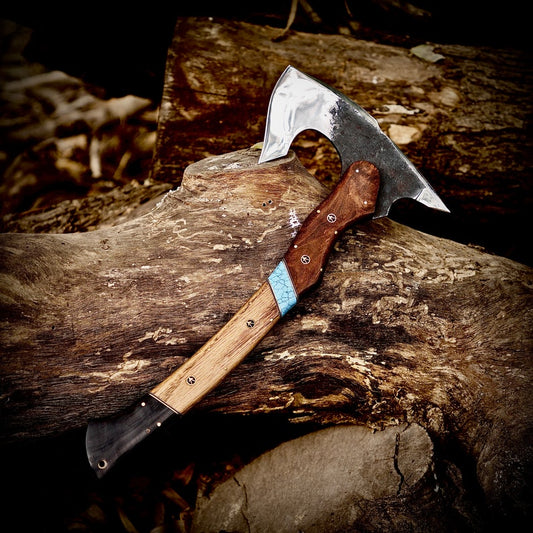 Two axes on a wooden log with a natural outdoor background