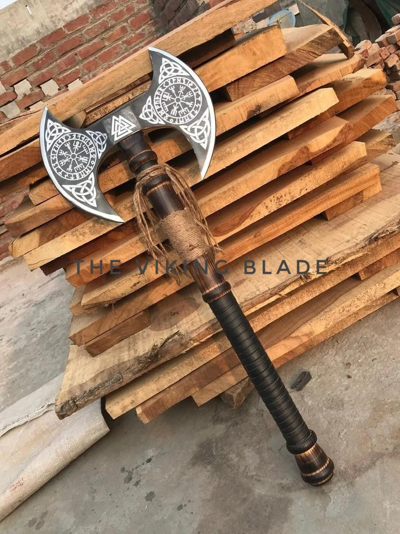 Viking-style axe with decorative blade on a wooden pallet, branded 'The Viking Blade'.