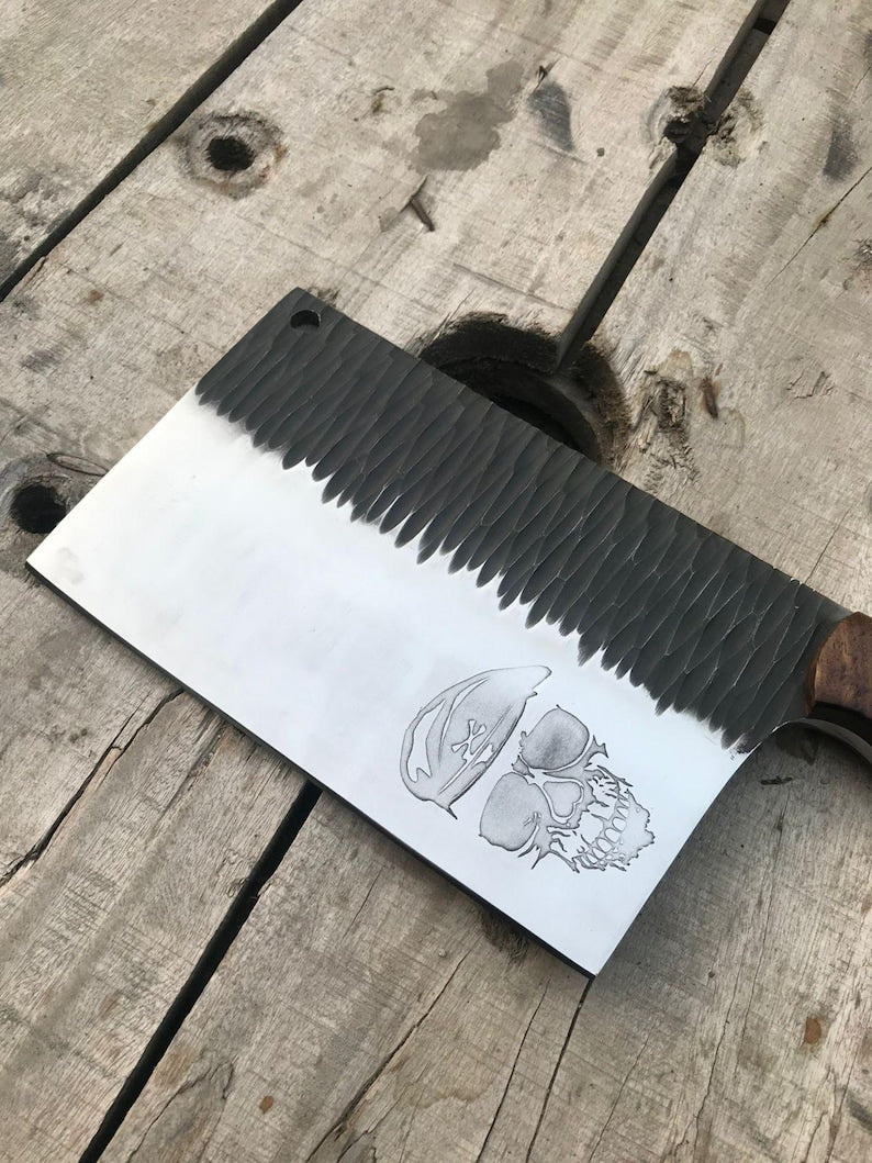 Meat cleaver with engraved design on a wooden surface