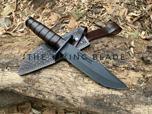 Knife with leather sheath on a wooden surface, branded 'The Viking Blade'.