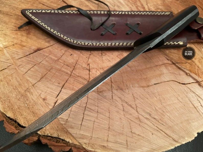 Hand-forged Damascus Seax knife with ergonomic wood grip for outdoor use.