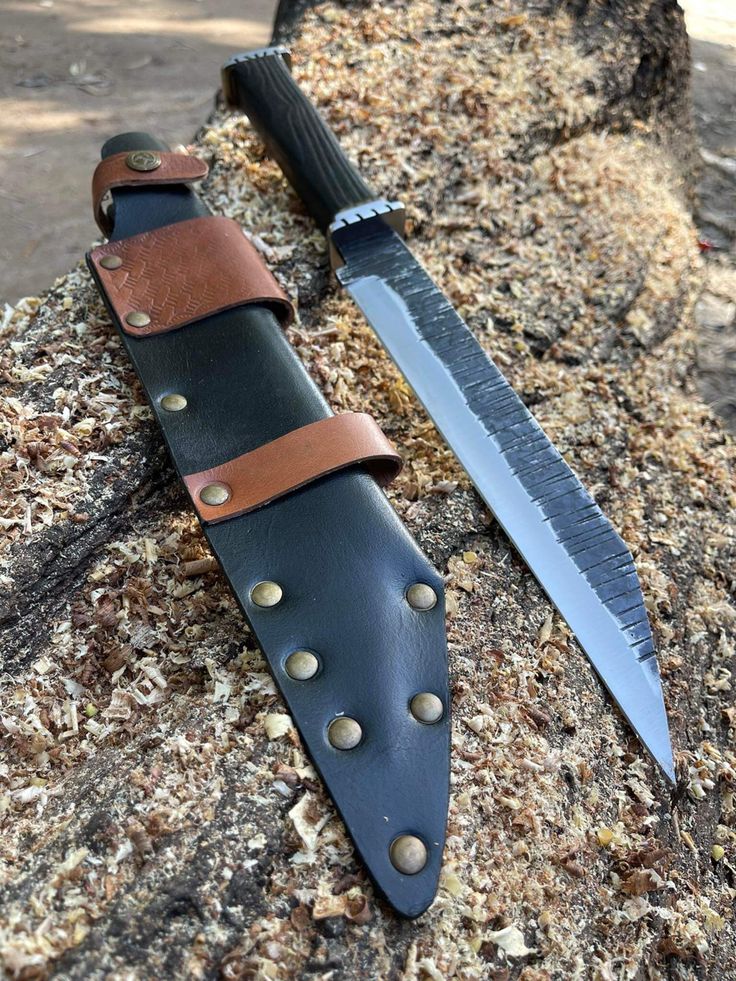Knife with leather sheath on a stone surface