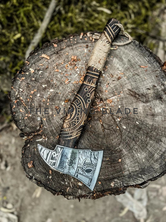 Decorative axe with intricate designs on a wooden stump
