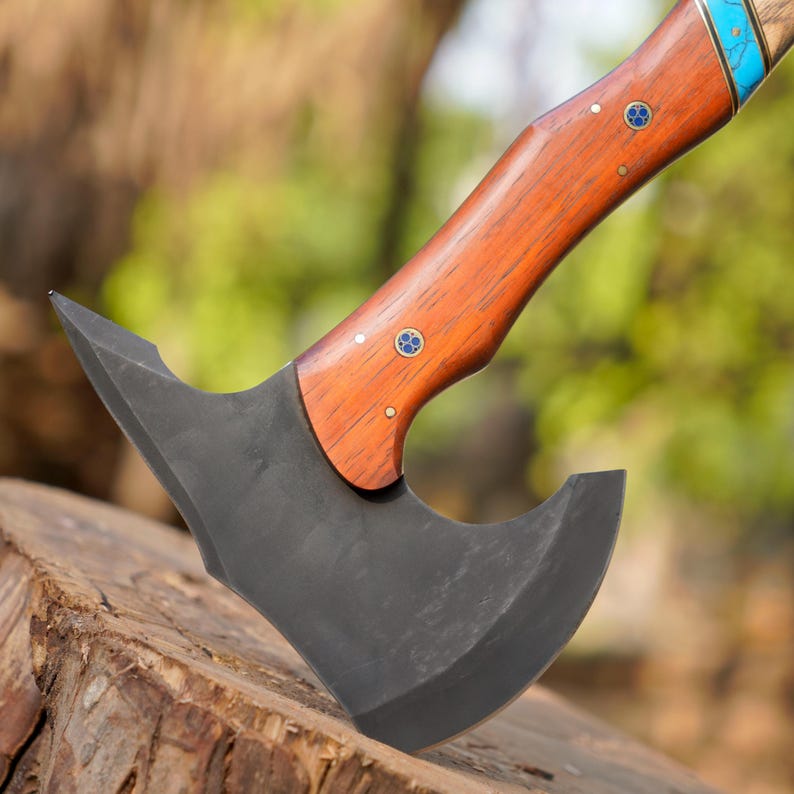 Wooden-handled axe with a gray blade on a blurred natural background