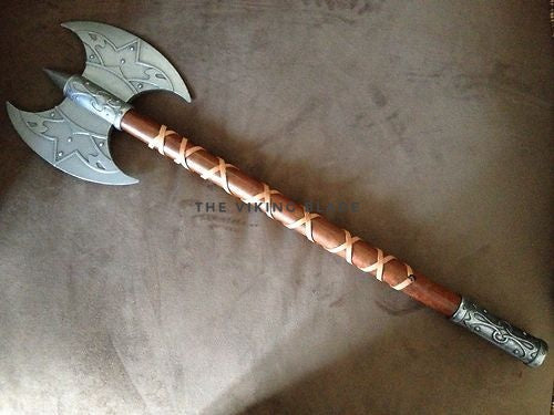 Decorative axe with a braided wooden handle on a textured surface