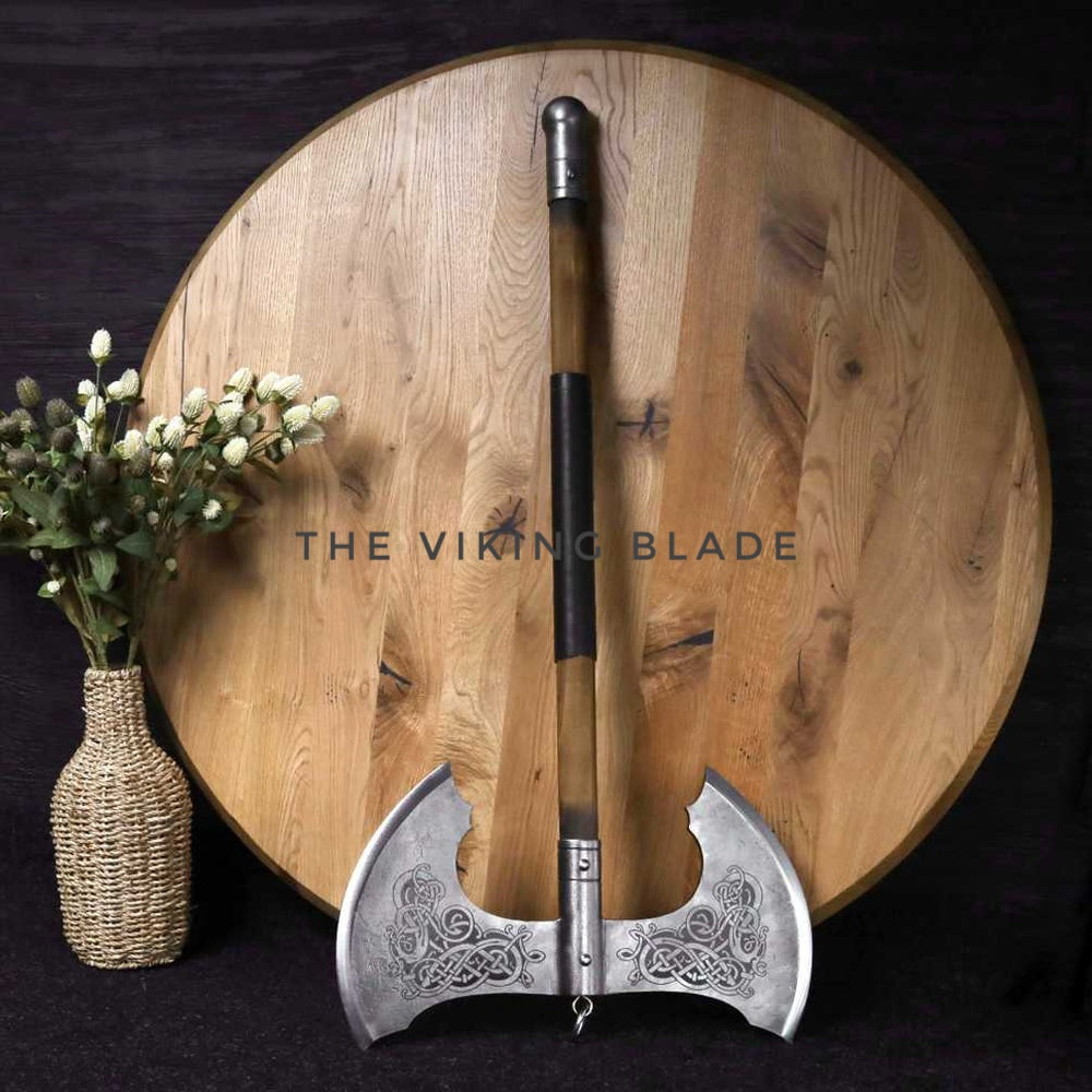 Decorative axe with intricate design on a wooden surface, branded 'The Viking Blade'.