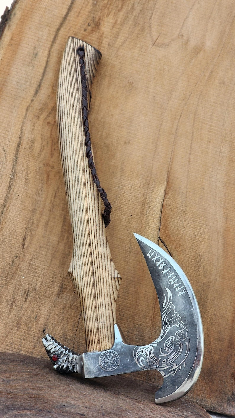 Decorative axe with wooden handle on a wooden background