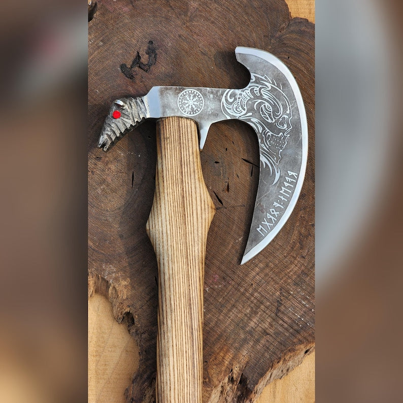 Decorative axe with a wooden handle and silver blade on a wooden background