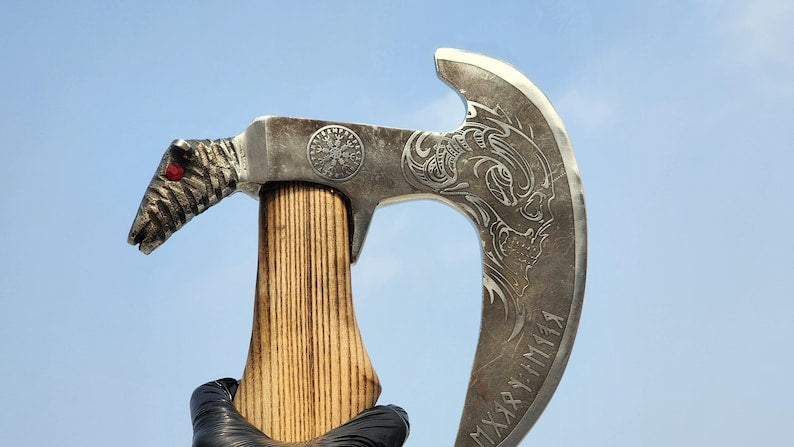 Decorative axe with wooden handle and metal blade against a clear blue sky