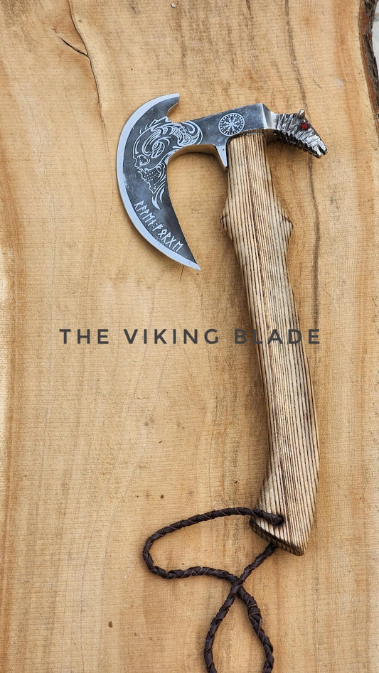 Viking-style axe with decorative blade on a wooden background, branded 'The Viking Blade'.