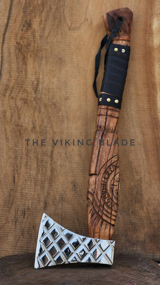Wooden axe with decorative patterns on a wooden background