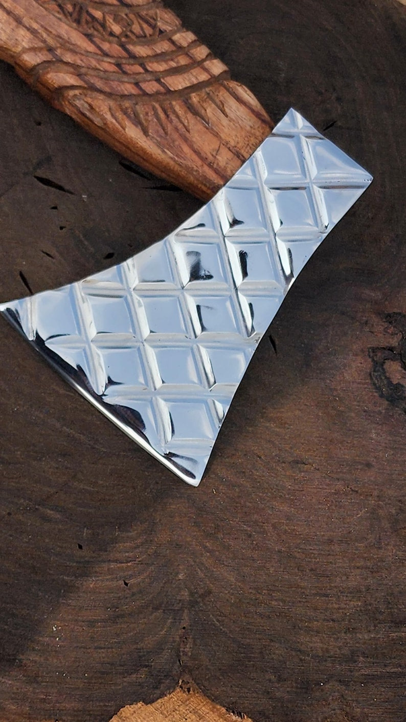 Metallic diamond-patterned tile on a wooden surface