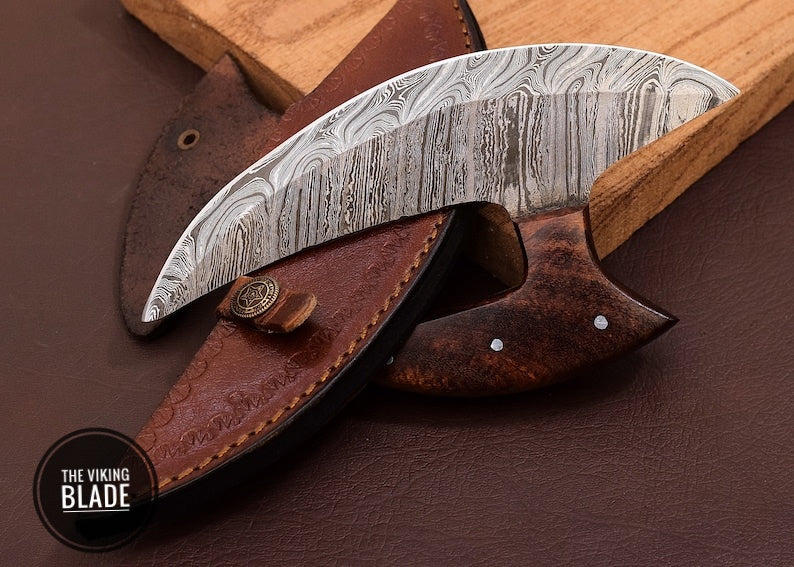 Handmade Damascus Ulu knife with elegant wooden stand and leather sheath displayed on white background