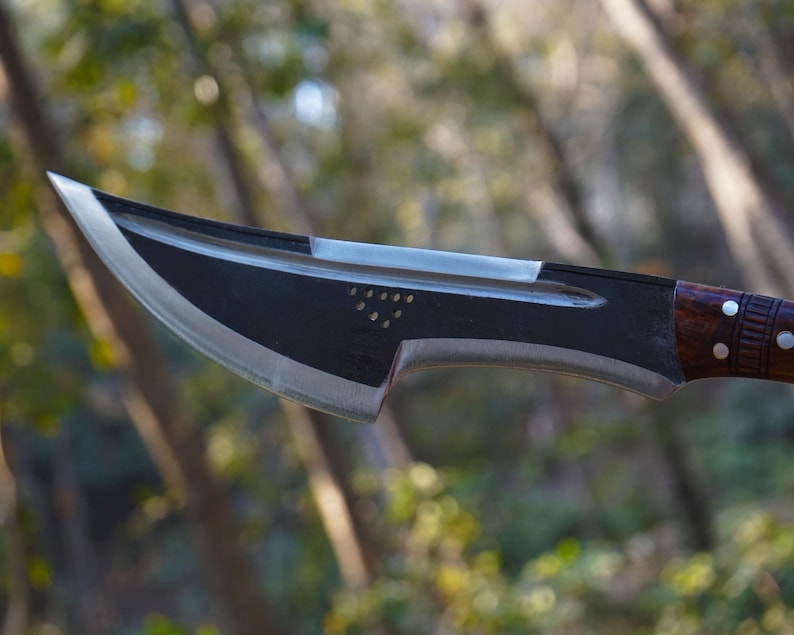 Sword with a wooden handle against a blurred natural background