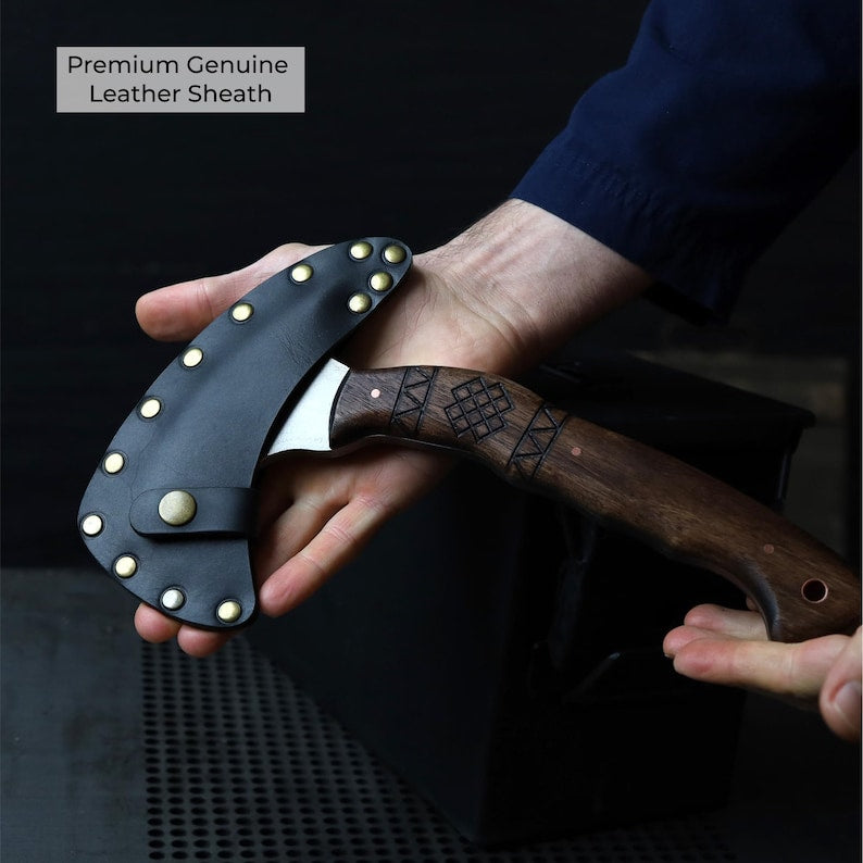 Hand holding a knife with a leather sheath against a dark background