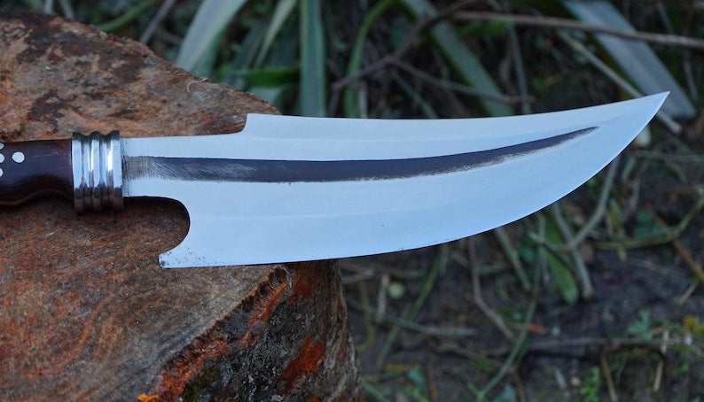 Knife with a wooden handle and metal clip on a natural background