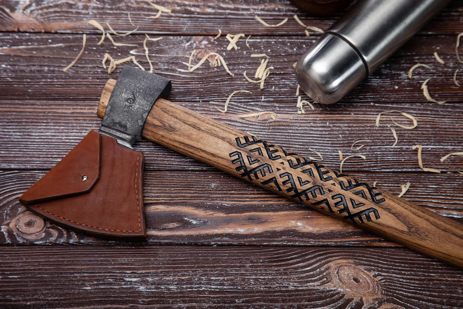 Wooden axe with leather sheath on a wooden surface