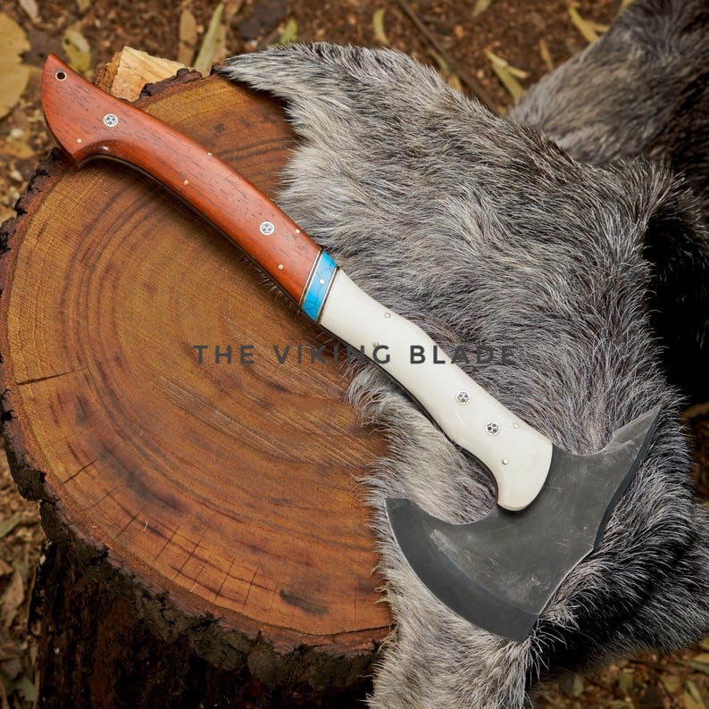 Viking-style axe with wooden handle on a wooden stump with fur background