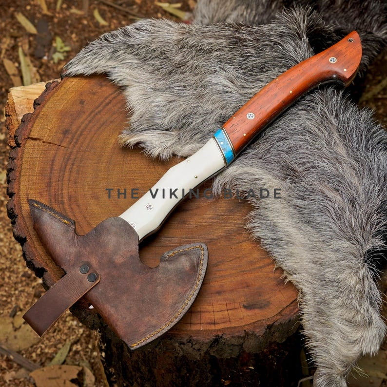 Wooden-handled axe with leather sheath on a wooden stump with fur.