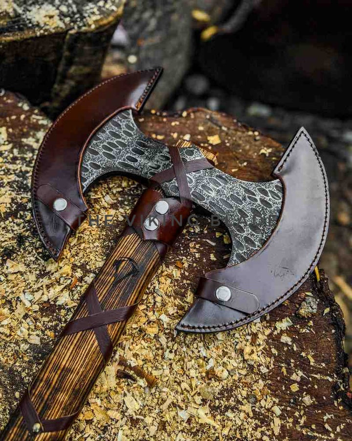 Two axes with leather sheaths on a natural background