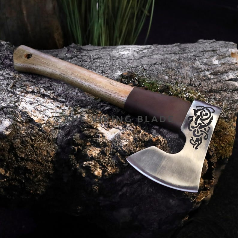 Decorative axe with a wooden handle on a textured surface