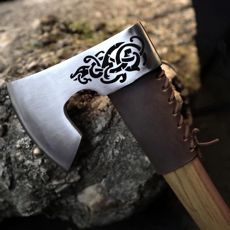 Decorative axe with a wooden handle against a natural stone background