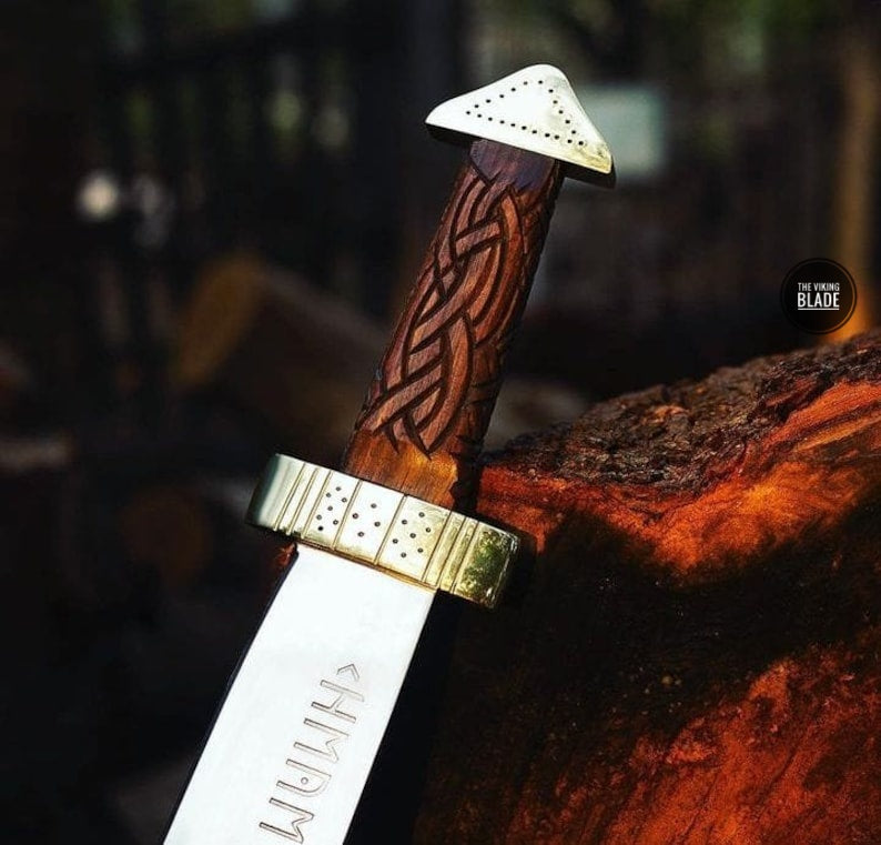 Traditional Viking Seax knife featuring a fully hand-engraved rosewood handle, brass pommel, D2 steel blade, and premium leather sheath.