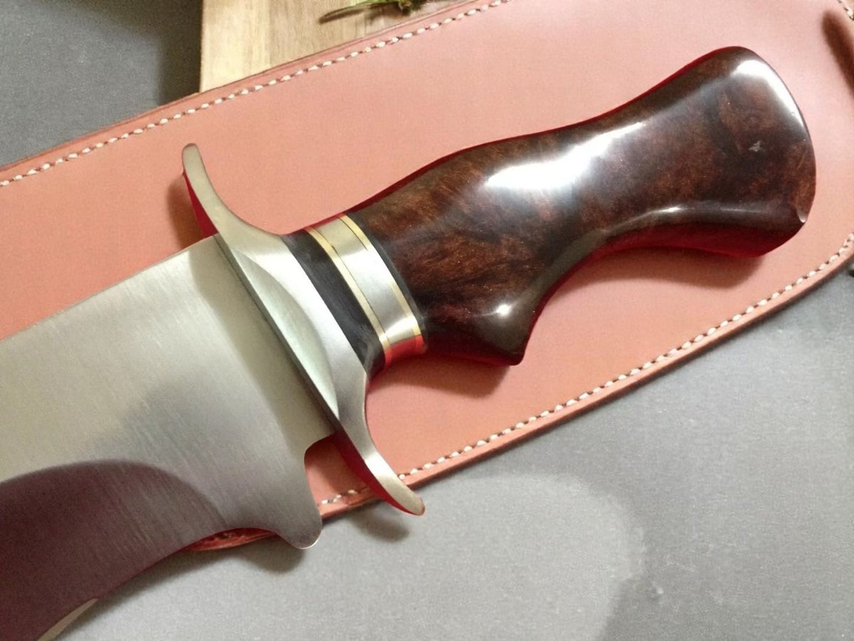 Close-up of a dagger with wooden handle and leather sheath.