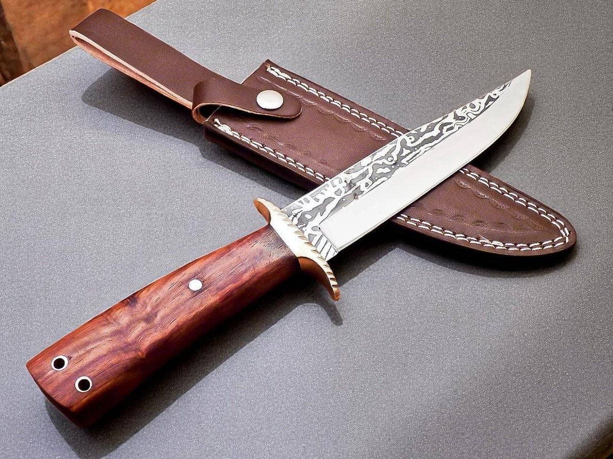 Decorative knife with wooden handle and leather sheath on gray surface