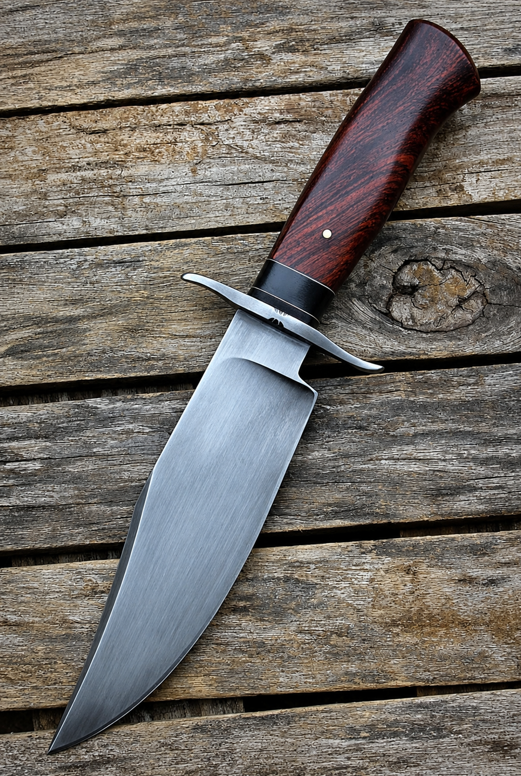 A fixed-blade knife with a satin-finished steel blade and a reddish-brown wood handle, placed diagonally on a rustic weathered wooden plank surface.