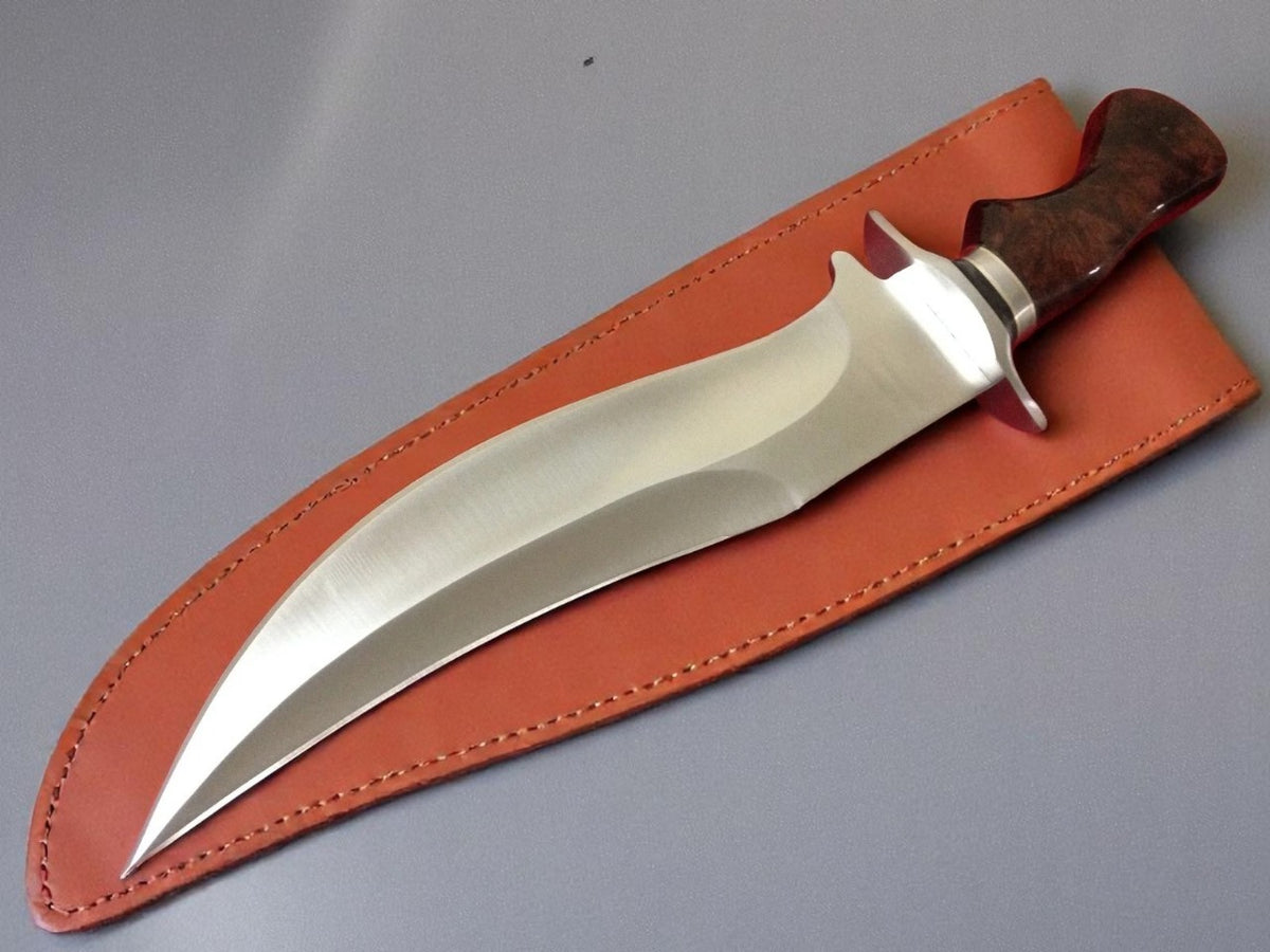 Knife with wooden handle in leather sheath on gray background