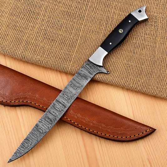 A fixed-blade knife with a patterned steel blade, a black handle with silver bolsters, shown resting on a brown leather sheath over a burlap and wood surface.