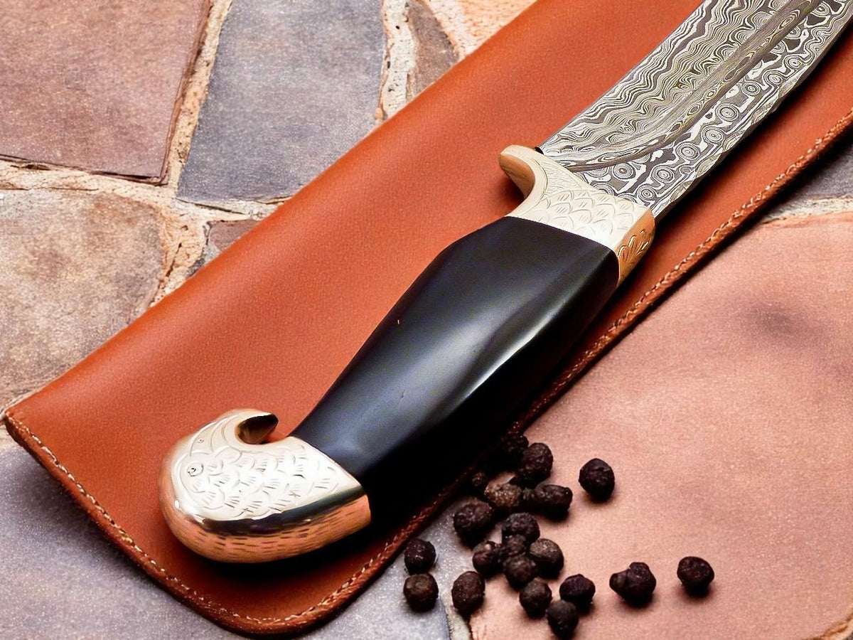 Decorative knife with black handle and silver blade in a brown leather sheath.