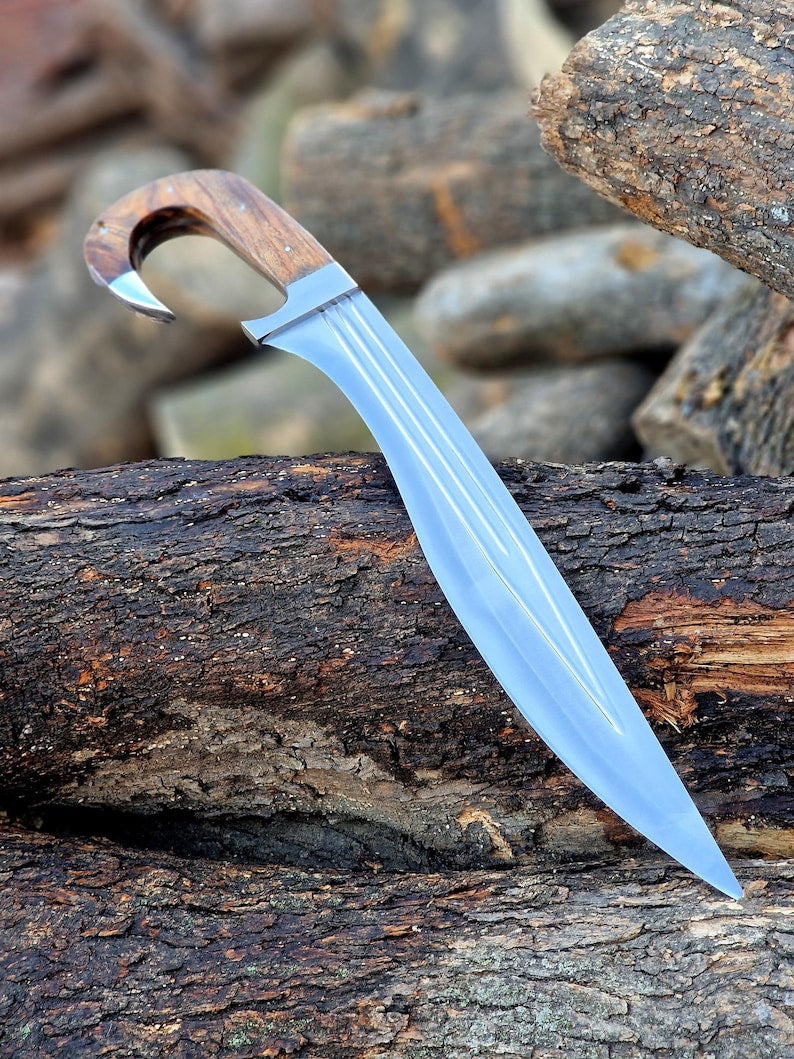 A fixed-blade knife with a silver steel blade and a brown wood handle, resting diagonally on a textured log outdoors.