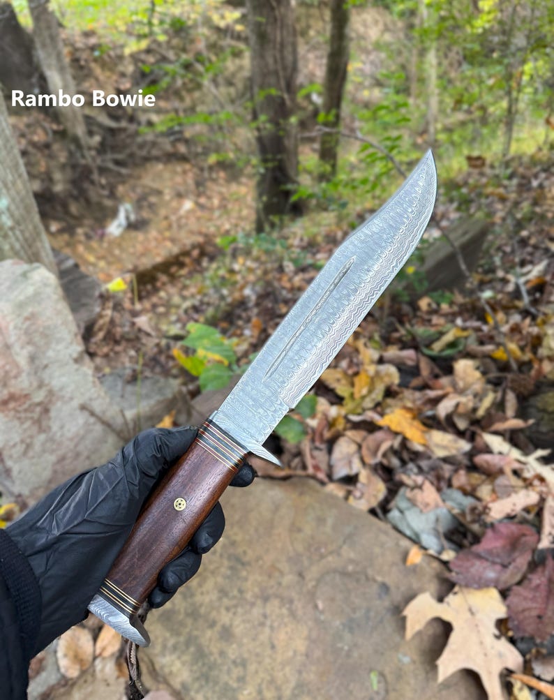 Knife held in hand with a forest background
