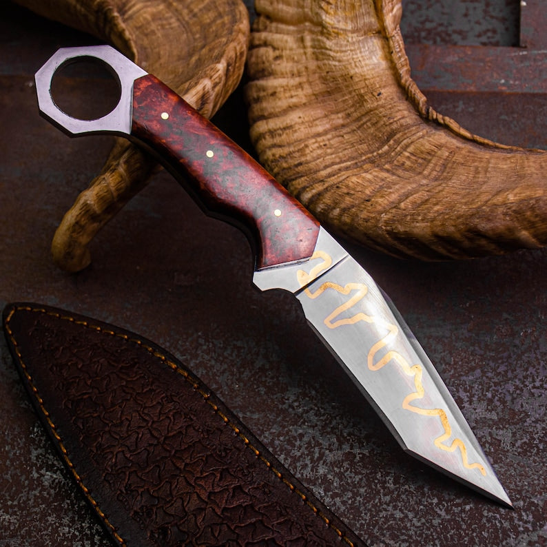 Knife with a wooden handle and decorative blade on leather background